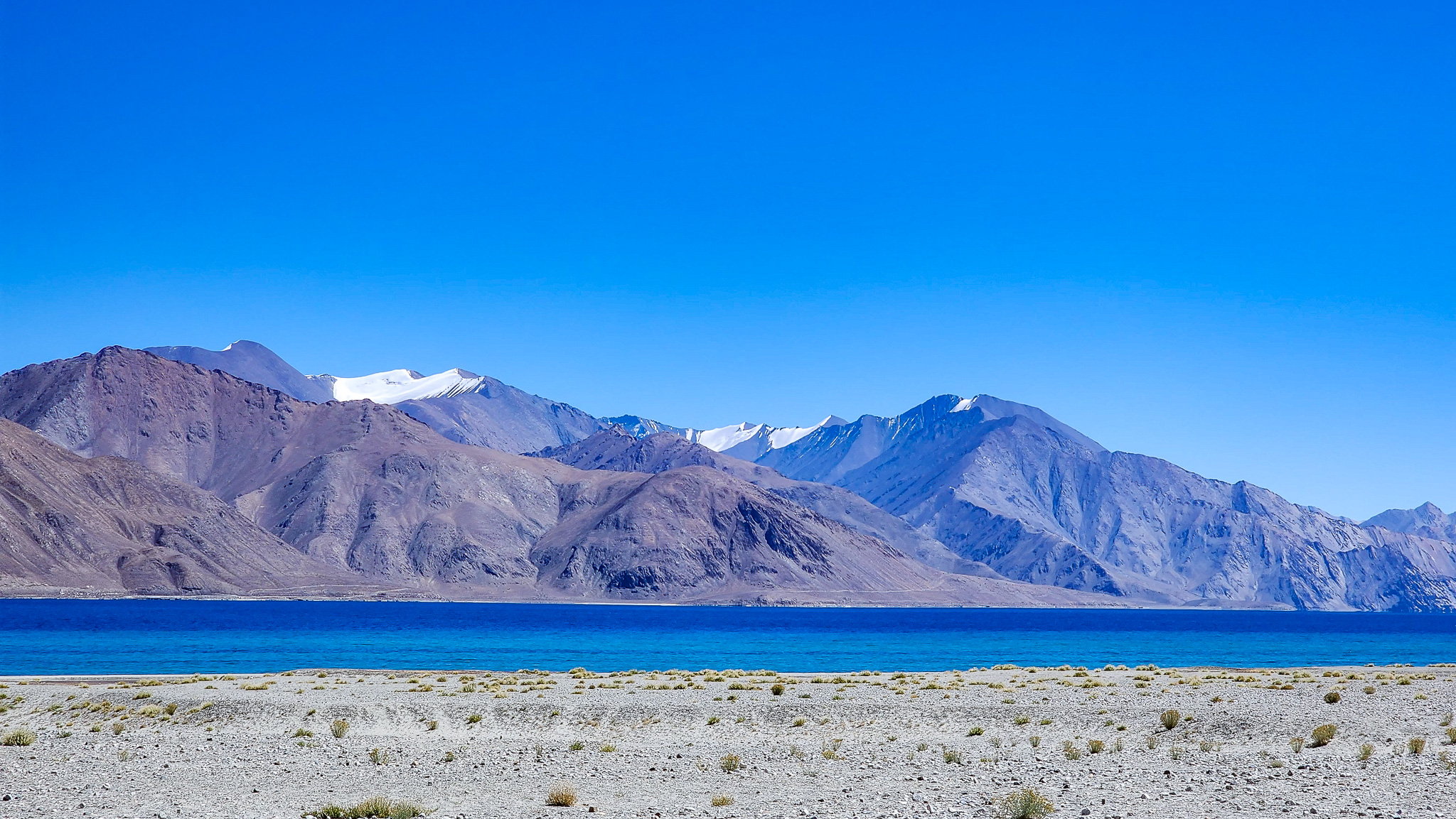 Panoramic view of Pangong Lake meeting mountain horizons in Ladakh