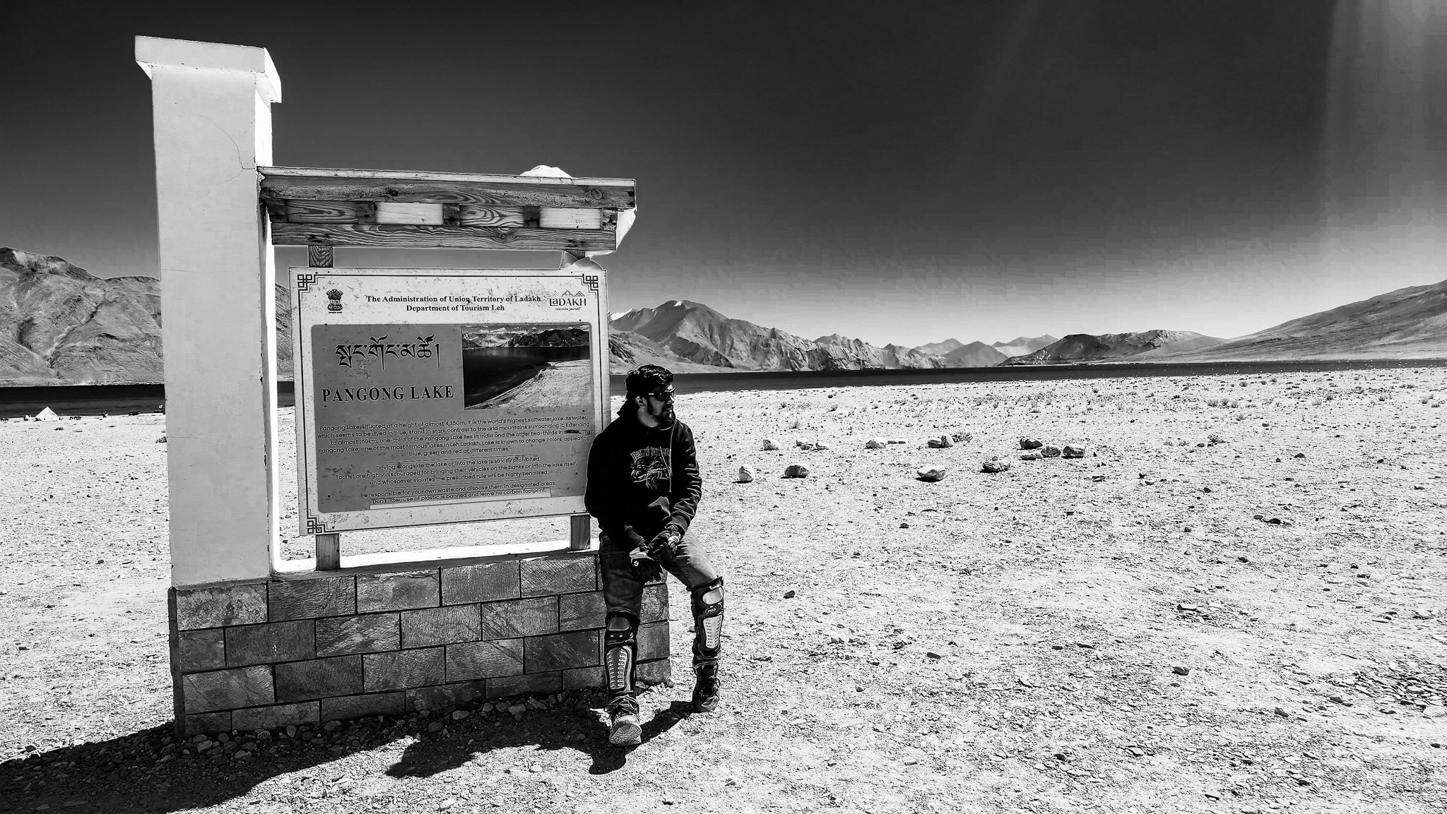 Black and white portrait of a traveller beside Pangong Lake